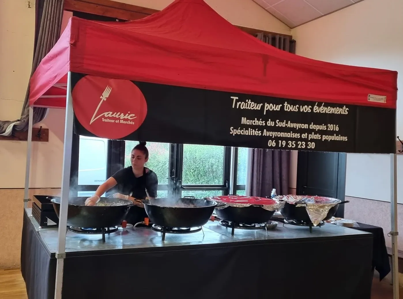 Photographie de Laurie Pelcis-Jayet, en train de préparer ses plats aveyronnais sur un marché local.