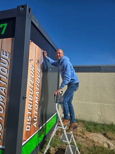 Un professionnel applique un habillage personnalisé sur un kiosque de distribution automatique de MonCasierFrais.fr