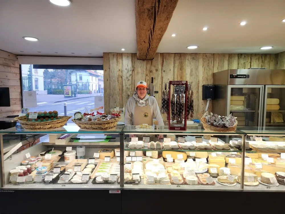 Yoann Duquesnoy derrière son étal de fromages - Fromagerie de la Plaine